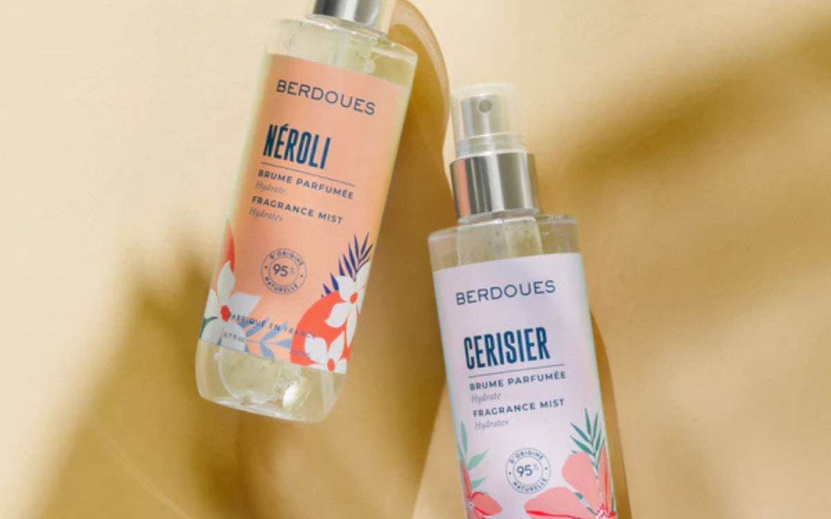 Deux brumes parfumées sans alcool Berdoues, aux notes de néroli et de cerisier, présentées sur un fond lumineux pour illustrer une alternative douce aux parfums traditionnels
