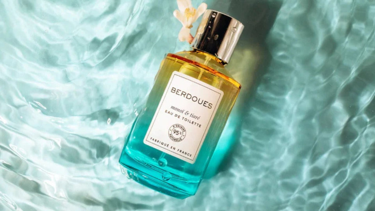 Flacon d'eau de toilette Berdoues Monoï & Tiaré flottant dans une eau turquoise, illustrant l'alliance entre parfumerie et émotion sensorielle